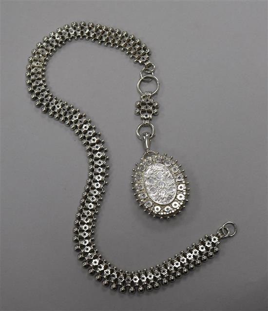 A late Victorian engraved silver oval locket on an ornate silver chain, locket 53mm.
